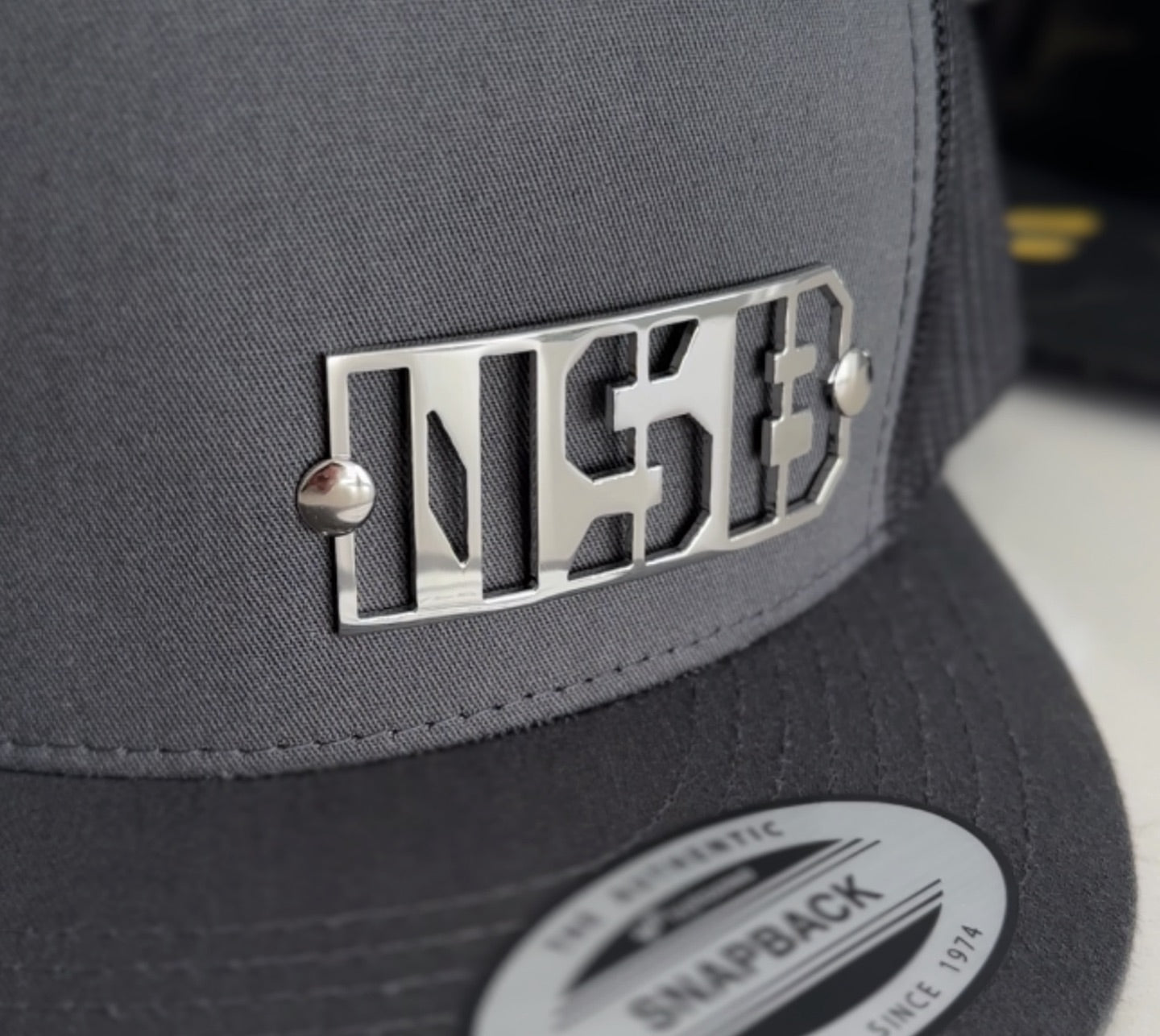 polished steel emblem on a snapback hat