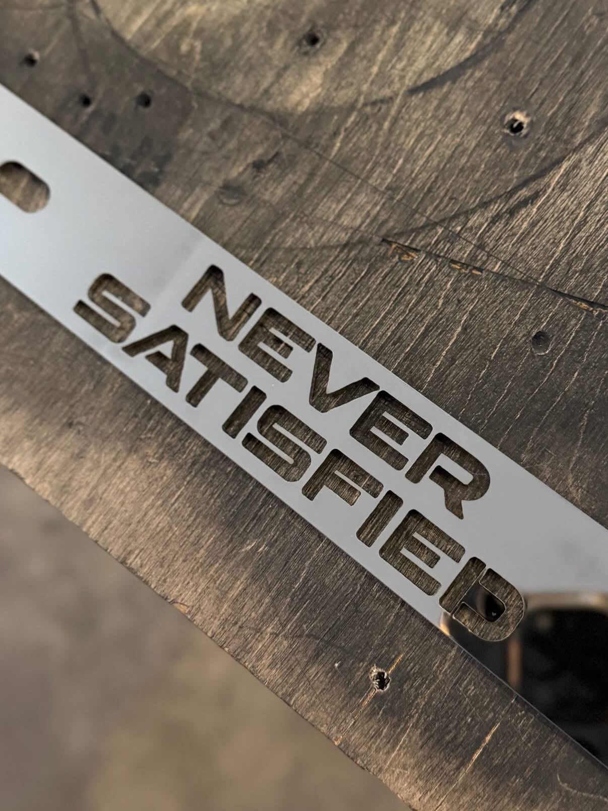 NEVER SATISFIED Stainless License Plate Frame