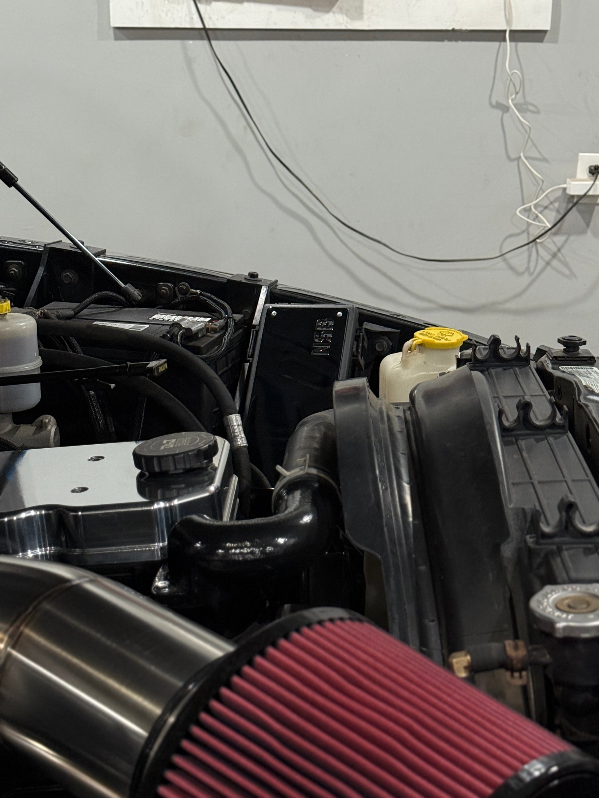 NSB Polished Fuse Box Cover Overlay for Dodge Cummins installed in the engine bay